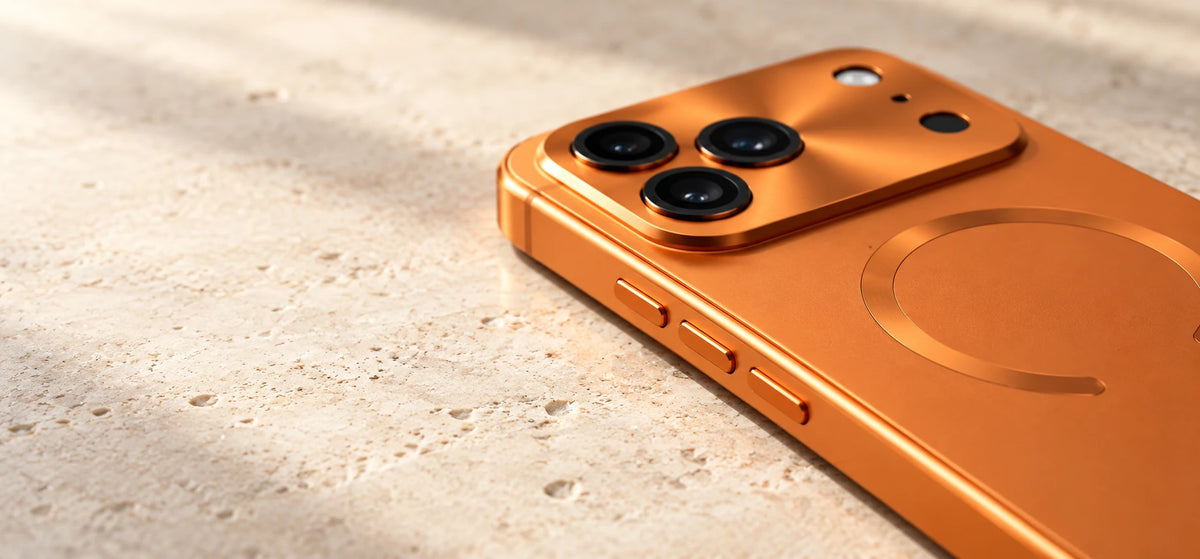 Close view of an orange alloy phone case showing the camera surround and three side buttons.